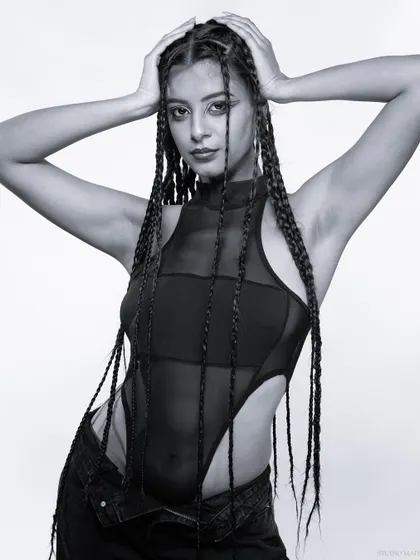 A powerful pose in black and white, with the model's hands behind her head.