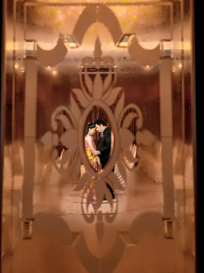 A wider view of the same creative shot, showing more of the ornate frame and the couple's embrace.