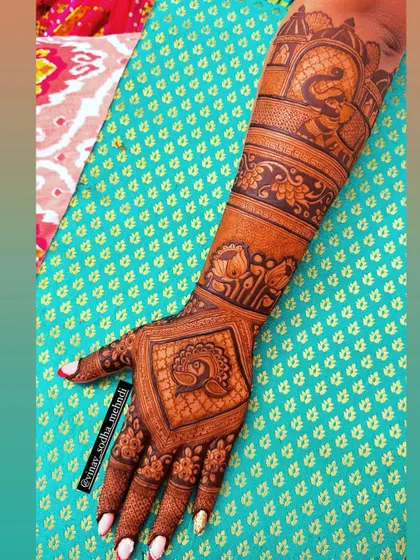 A full-arm back-hand design with a mix of peacock, elephant, and architectural motifs. A truly classic bridal style.
