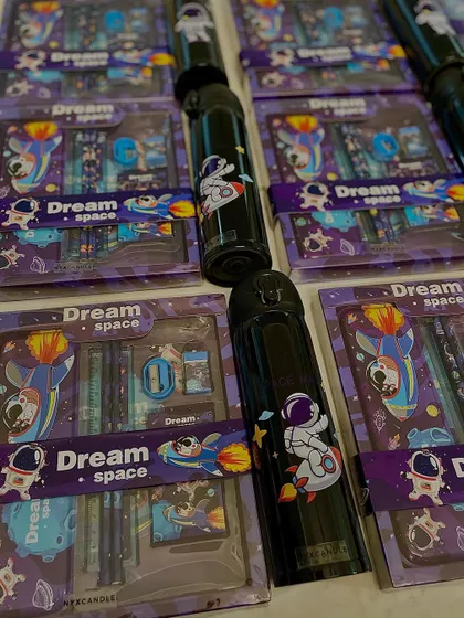 Rows of our Space-themed stationery sets and water bottles, ready to be packed into hampers for a birthday celebration.