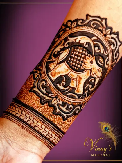 An arm band featuring a majestic elephant in an ornate circular frame. The dark, rich stain makes the design pop.