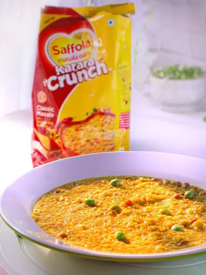 A product shot of Saffola Masala Oats, styled to look like a warm, comforting meal. The steam effect and bright lighting emphasize that it's a hot and healthy breakfast option.