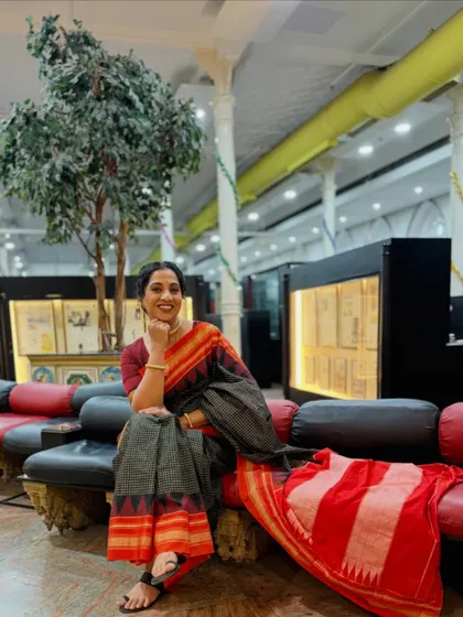 A relaxed moment during the photoshoot. Madhurani looks elegant in a black and red handloom saree, with makeup that is understated and sophisticated.