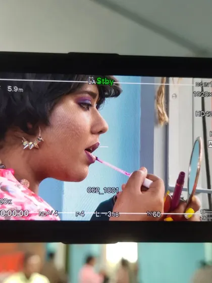 A candid shot captured on the monitor during the 'Nikki Raid' shoot. This behind-the-scenes photo shows a moment of quiet focus before the camera rolls.