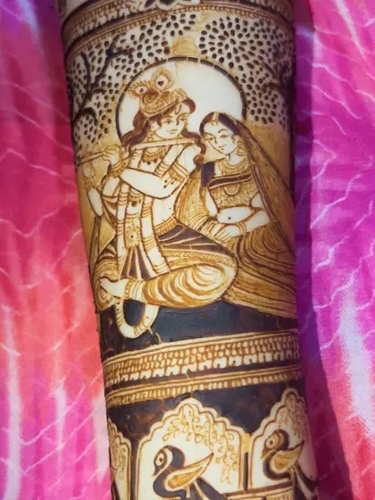 A beautiful portrait of Radha and Krishna under a tree, created with delicate lines and shading on the bride's arm.