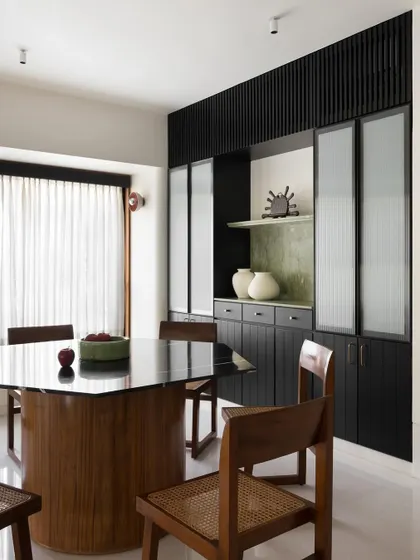 The hexagonal dining table I designed, seen here with its accompanying chairs. The dark, polished top reflects the light, adding depth and sophistication to the dining area.