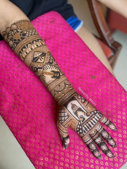 A full-arm bridal design with a mix of peacocks, kites, and architectural elements, showcasing a variety of motifs in one piece.