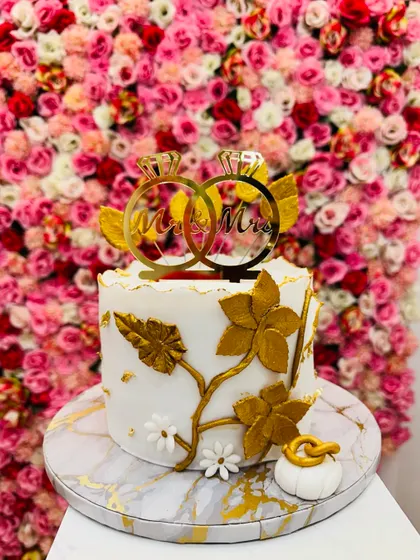 A sophisticated 1.5 kg Dutch Truffle engagement cake. The white and gold design with a marble-effect base and a "Mr & Mrs" topper is perfect for a modern couple.