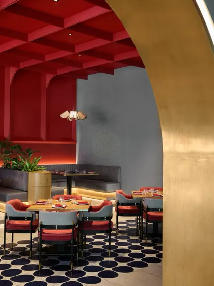 A view through a gilded archway, showing how we layer spaces to create depth and intrigue, making the restaurant feel more expansive.