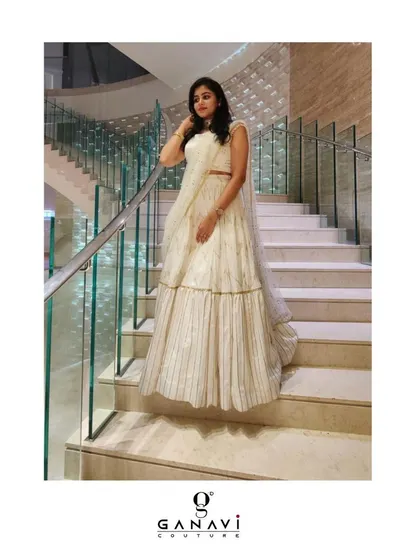 A client looking stunning in a white gota patti and mukaish lehenga ensemble. The tiered skirt and intricate work create an excess of charm and elegance.