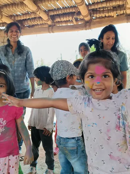 A joyful, color-smeared child reaches out for a hug. Our field trips are as much about emotional connection and fun as they are about learning.