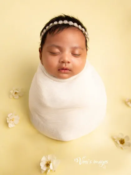A minimalist portrait using a simple swaddle and a soft, solid color background. This style creates a timeless image that emphasizes the baby's perfect form.