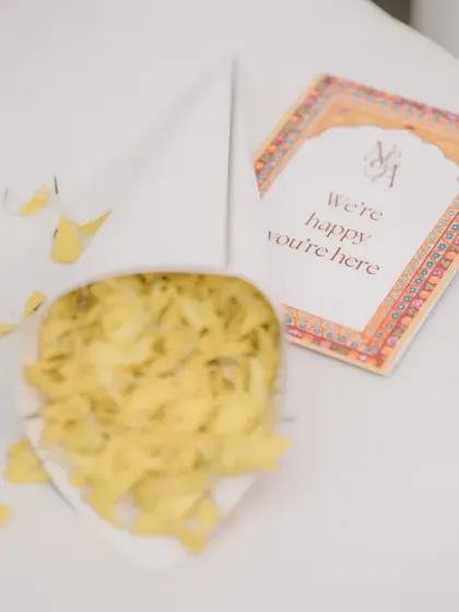 A personalized welcome note and a cone of flower petals for guests, adding a thoughtful touch to the Haldi ceremony.