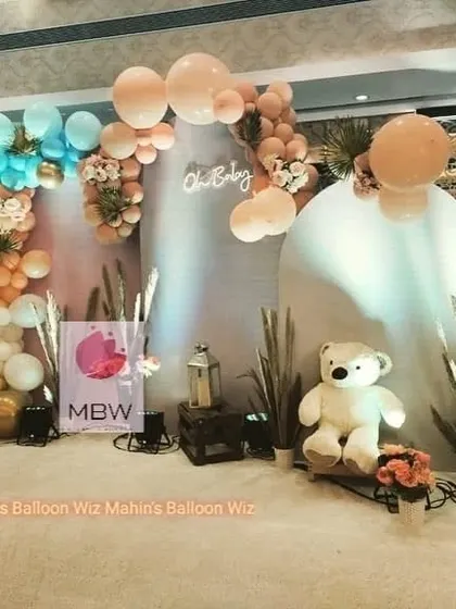 A minimalist and modern "Oh Baby" setup. The decor uses soft pastel balloons, pampas grass, and a clean white backdrop for a serene and stylish celebration.
