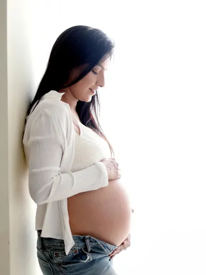 A high-key portrait in jeans and a simple top. This bright and airy style is perfect for creating a fresh, modern, and relaxed maternity photo.