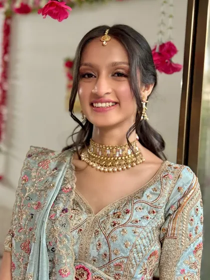 A fresh and youthful look for a pre-wedding function, featuring a pastel blue lehenga and minimal, glowing makeup.