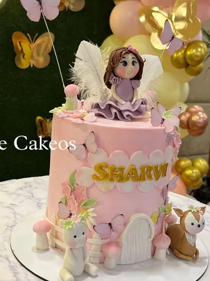 Another view of the fairy garden cake, showing the placement of the fondant creatures and the door to the fairy house.
