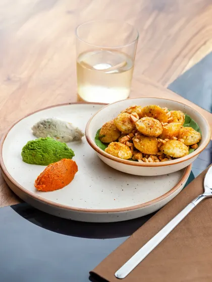 A beautifully plated serving of our Lemon Gunpowder Idli, accompanied by a refreshing drink. This is modern Indian snacking at its finest.