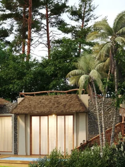 The architecture of Dev Villas in Kanha, surrounded by palm and pine trees. The use of thatched roofs and natural materials helps the buildings merge with the dense greenery.