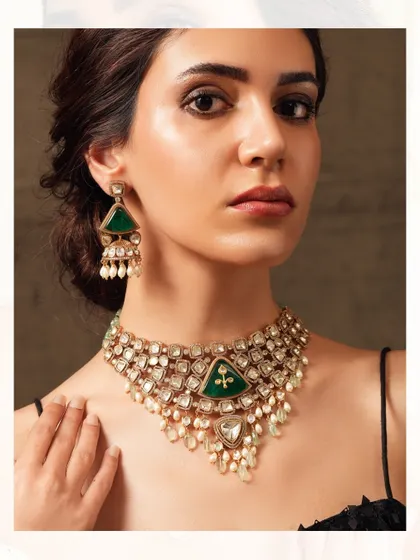 A modern take on a traditional design, this polki and emerald necklace features triangular motifs and pearl drops.