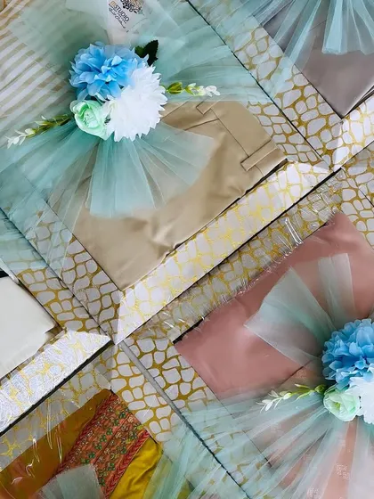 A mix of traditional and western wear packed for an engagement. The consistent color theme in the wrapping unifies the diverse gifts into a single, stunning presentation.