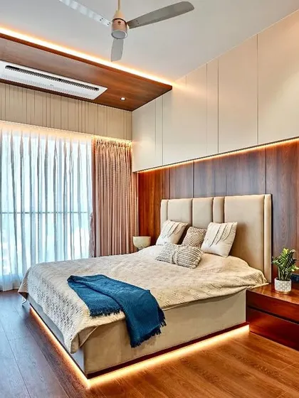 Beautiful and timeless is what we aim for. This bedroom showcases a serene combination of materials, with a wood-paneled feature wall, a simple upholstered headboard, and subtle under-bed lighting.