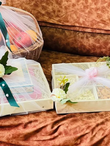 Two distinct trousseau pieces, a gift box and a dry fruit box, each with its own unique floral accent. This shows how I can create variety within a single theme.