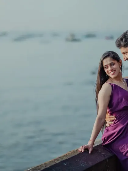 A happy, candid moment by the Mumbai waterfront. The sea and the distant boats provide a classic urban backdrop for a relaxed and romantic pre-wedding portrait.