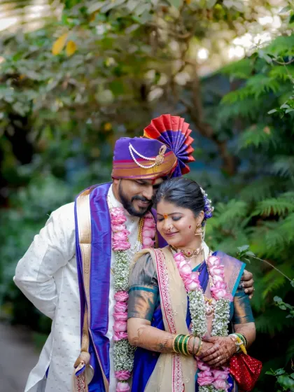 A tender embrace between the couple, their 'varmalas' adding to the beauty of their traditional wedding look.