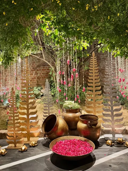 One of our versatile decor trees, here styled with brass leaf cutouts and bowls of rose petals for a traditional look.