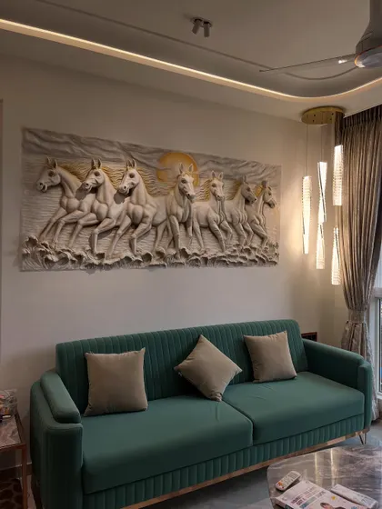 The monochrome 7 horses mural seen with different lighting, highlighting the subtle golden sun in the background and the intricate details of the relief carving.