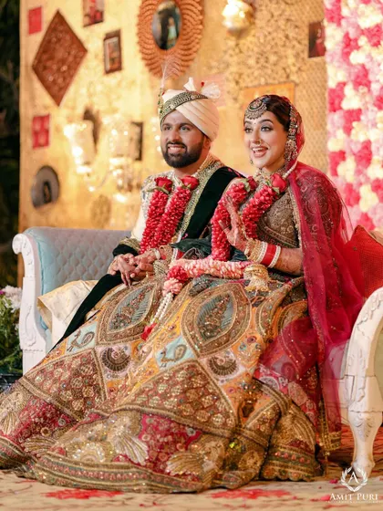 A happy, relaxed portrait of the couple seated after their wedding rituals. Their smiles show the joy and relief of being officially united.
