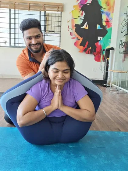 A smile of accomplishment in a deep hip-opening pose. My role is to provide the support needed to help you comfortably explore your body's limits.
