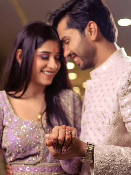 A close-up of the couple holding hands, showcasing the engagement ring and their happy smiles.