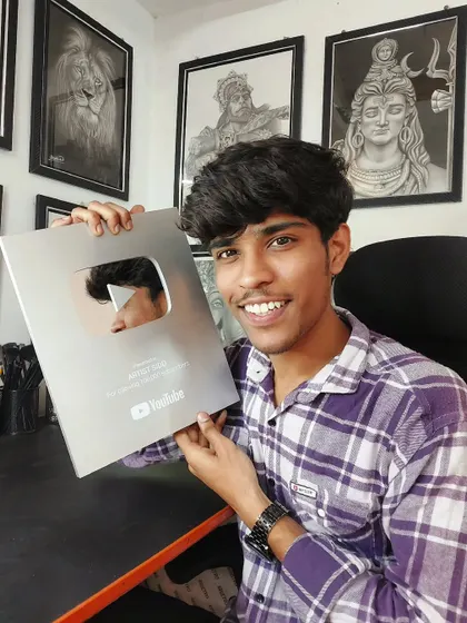 A smiling photo with my YouTube silver play button, surrounded by my artwork. This is a milestone I will always cherish.
