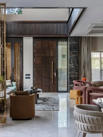A closer look at the entrance of this living space, where a custom wooden door and intricate metal screen set a luxurious tone. The design ensures that every element, from the entrance to the seating, contributes to a cohesive aesthetic.