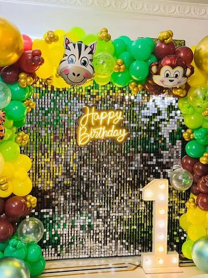 A close-up of the Jungle Safari theme, showing the shimmer wall, neon sign, and animal foil balloons. This setup is perfect for a wild first birthday adventure.
