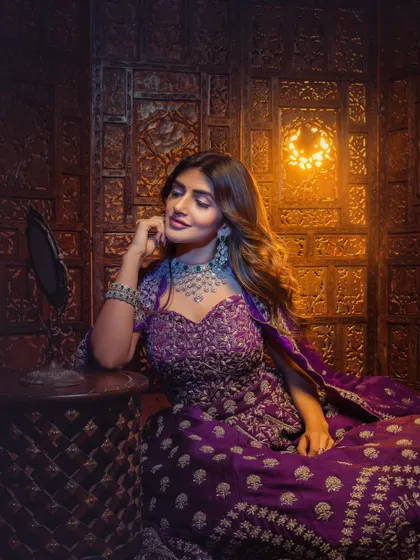 A softer moment from the shoot with Sreeleela. The styling here focuses on the intricate details of the purple lehenga and the sparkling diamond choker, creating an image of quiet elegance.