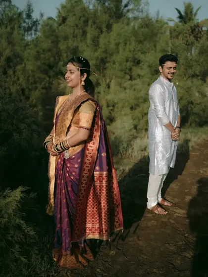 An artistic shot of the couple standing apart in a natural setting, creating a sense of anticipation and connection.