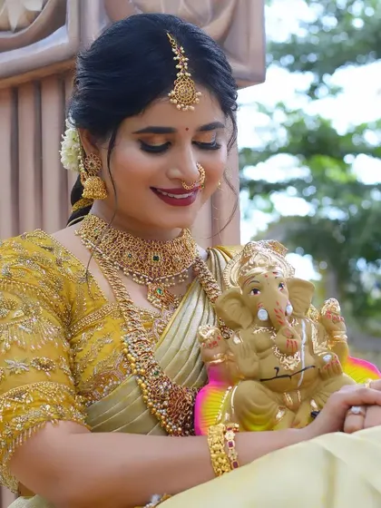 A model celebrating Gowri Ganesha, dressed in a golden saree and a complete temple jewellery set.