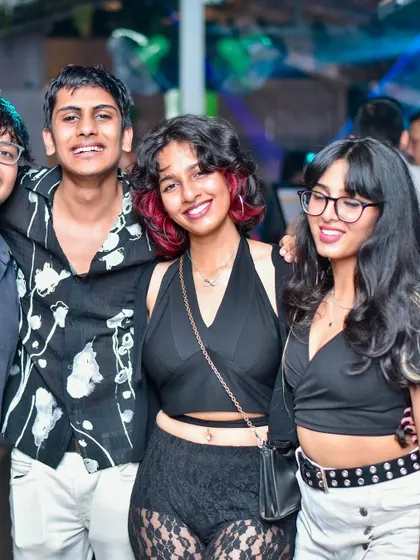 A group of young partygoers having a great time and posing for a photo.