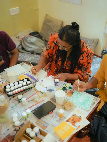An attendee focuses on her artwork during the "Paint with Kittens" event. The calm and creative atmosphere is made even better by the presence of our playful kittens.