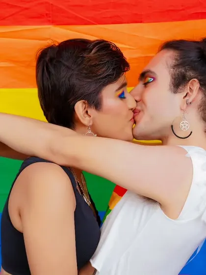 An intimate and important photo from the Pride shoot, capturing a kiss in front of the rainbow flag. It's a celebration of love in all its forms.