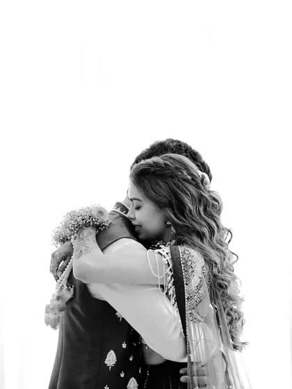 A powerful black and white shot of an emotional embrace. This image focuses on the raw feeling and connection, stripping away all distractions to show a moment of pure love.