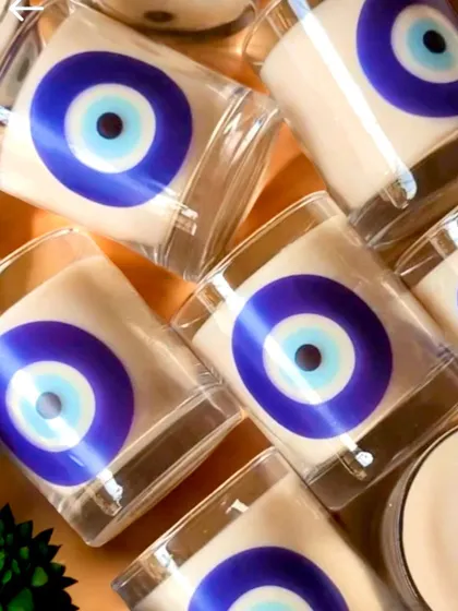A set of scented candles in glass jars featuring the protective evil eye motif. These are great for bulk orders and add a lovely ambiance to any home during the festival.