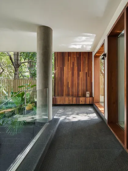 The entrance passage at Kanasu, where the interplay of concrete, wood, and natural light guides you into the sanctuary of the home.