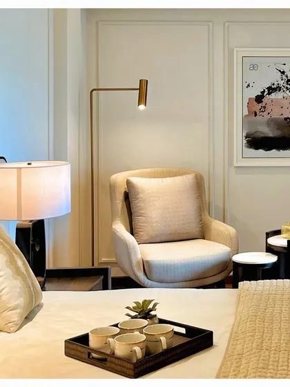 A cozy reading corner in the DLF apartment bedroom, complete with a comfortable armchair, side tables, and focused lighting. These small, thoughtful spaces are essential for creating a true sense of home.