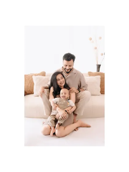 A beautiful, bright family portrait. The clean, minimalist setup allows the family's joy and connection to be the complete focus of the photograph.