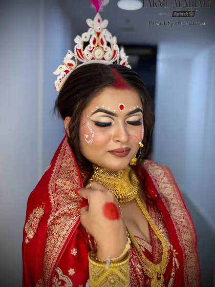 A beautiful and soft portrait of a Bengali bride. The makeup emphasizes a natural glow, with a focus on the eyes and the traditional bindi and chandan art.