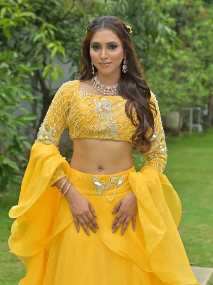 A full-body shot showing the complete yellow lehenga, a perfect blend of traditional color and modern design.